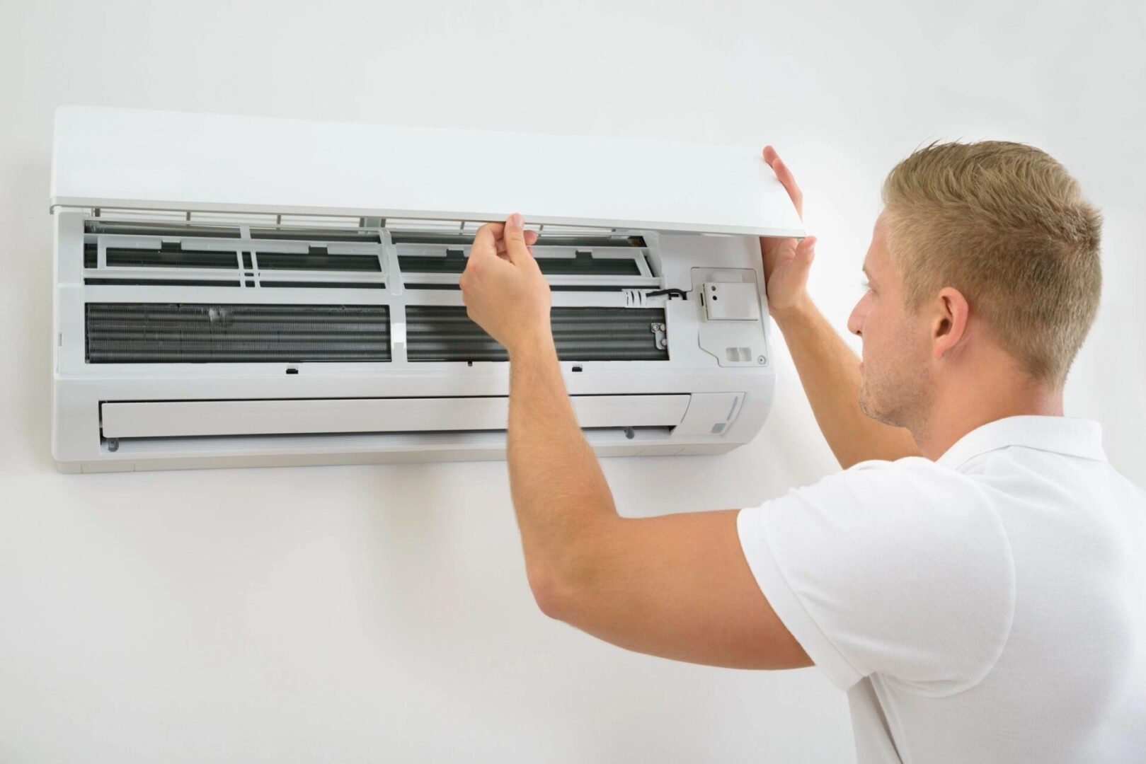 Portrait Of A Young Man Adjusting Air Conditioning System